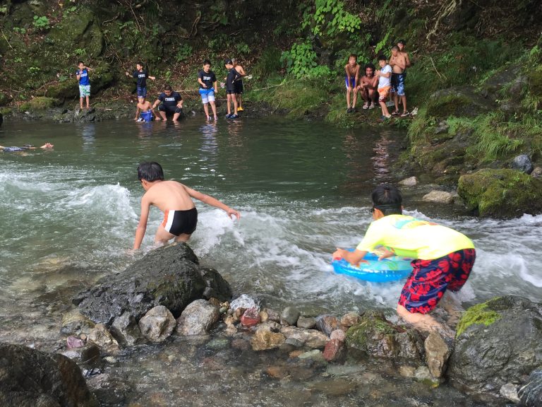 名栗川の流れの中で遊ぶ子どもたち